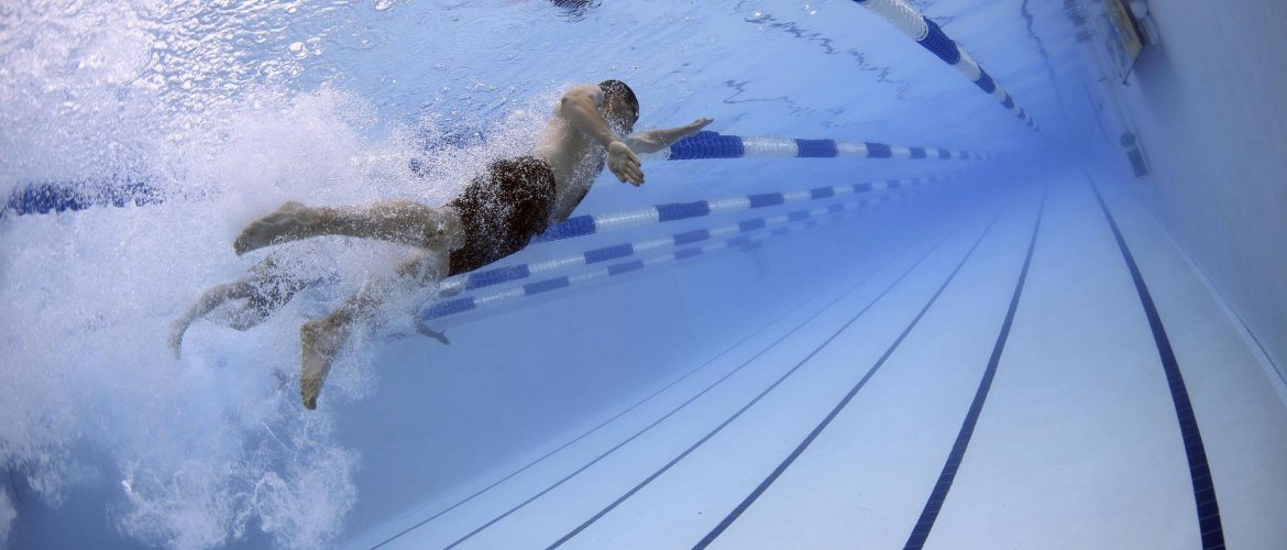 Un hombre nada en una piscina