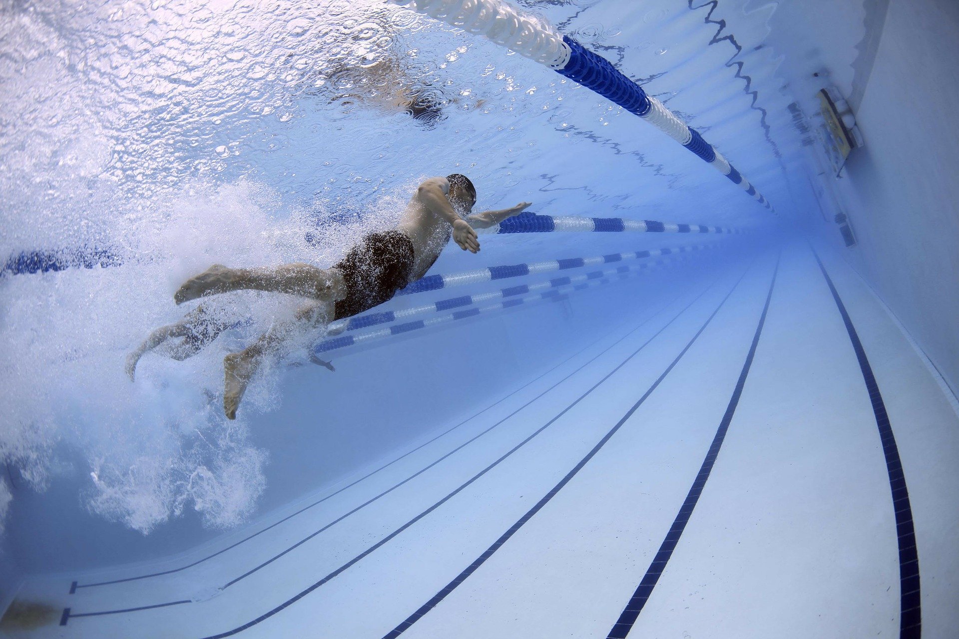 Un hombre nada en una piscina