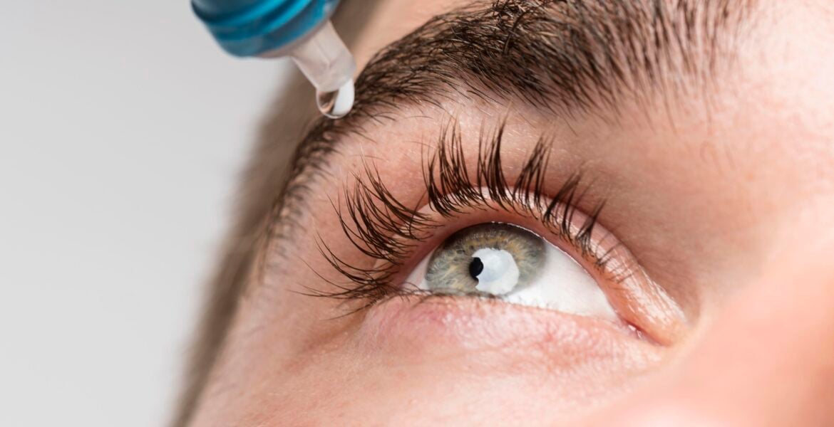 hombre guapo con primer plano de gotas para los ojos