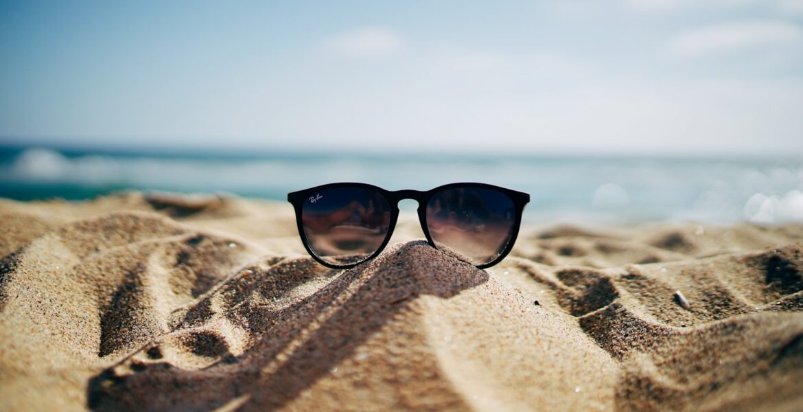 Gafas de sol apoyadas sobre la arena de la playa