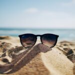 Gafas de sol apoyadas sobre la arena de la playa
