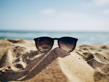 Gafas de sol apoyadas sobre la arena de la playa