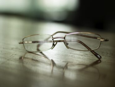 Gafas graduadas apoyadas sobre una superficie de madera